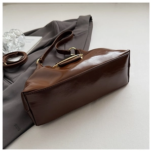 Detail view of the polished coffee brown PU leather hobo bag with gold metal hardware buckle