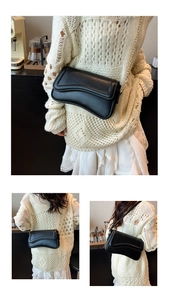 Détail du sac à bandoulière asymétrique noir avec chaîne dorée sur pull en maille