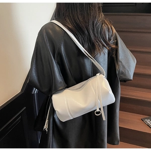 Detailansicht der weißen Zylindertasche mit langem Reißverschluss-Detail am Ledermantel