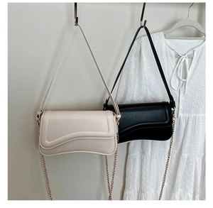 Détails de sacs sous les bras au design asymétrique avec bandoulières en chaîne dorée