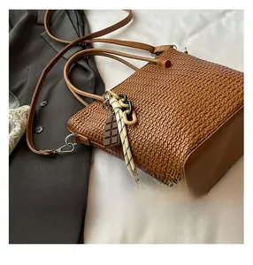 Macro shot of brown woven leather texture with decorative ribbon and chocolate charm