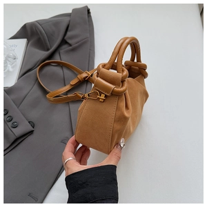 Detail of camel suede pleated cloud bag with gold hardware and leather handle