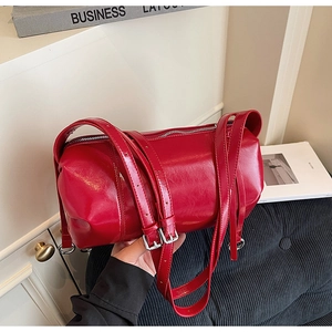 Detailansicht der roten Zylindertasche mit verstellbaren Riemen und Silberschnallen