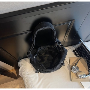 Vue de dessus du sac hobo en denim noir montrant le grand volume et la poche interne