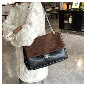 Macro detail of vintage quilted tote bag featuring brown suede and black leather patchwork