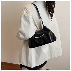 Detailed view of black pleated PU leather hobo bag with a gold crescent buckle closure