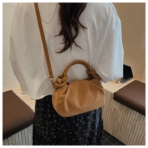 Brown suede ruched cloud bag with top handle and adjustable strap shown on model