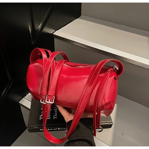 Detail der roten Zylindertasche aus glänzendem Softleder mit silbernen Metallschnallen