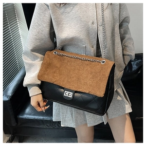 Detail of quilted tote bag featuring brown suede flap and silver chain shoulder strap