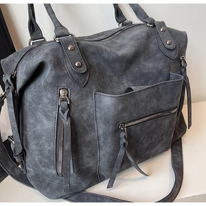 Dettaglio della borsa tote vintage in pelle scamosciata grigia con tasche con zip e metallo