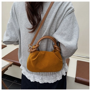 Close-up of caramel suede pleated handbag with retro hardware and leather handle