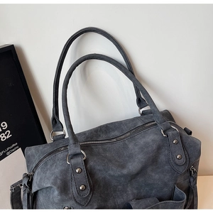 Dettaglio della borsa tote grigio scuro in finta pelle vintage con rivetti argentati