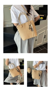 Detail of hand-woven straw bucket bag with leather handles and braided tassel accessory