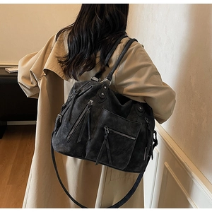 Dettaglio della borsa tote in pelle scamosciata con tasche a zip e decorazione di frange