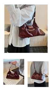 Close-up of deep wine red glossy crescent bag featuring iconic gold metallic buckle hardware