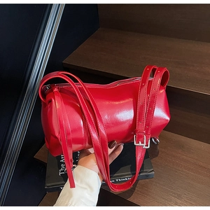 Makroaufnahme der roten Zylindertasche mit silberner Metallschnalle auf dunklem Grund