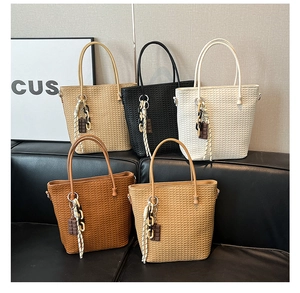 Close-up of woven bucket tote bags in five colors with decorative chocolate charms