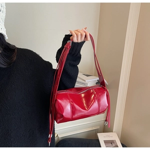 Nahaufnahme der glänzenden roten Boston-Tasche mit silbernem Reißverschluss und Ledertextur