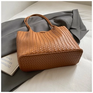 Détail de la texture tressée caramel et de l'anse solide de ce grand sac fourre-tout