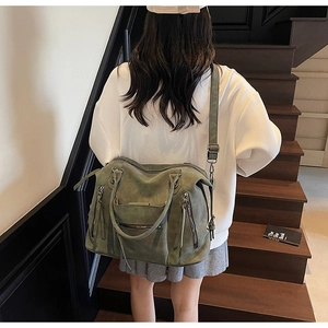 Dettaglio borsa tote verde scuro in pelle scamosciata con frange e tracolla regolabile