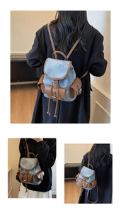 Detail of blue denim and brown leather backpack with drawstring closure and side pockets