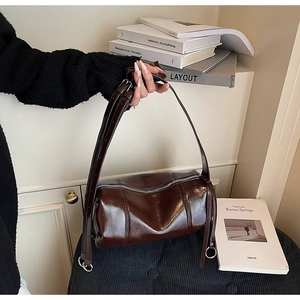 Detailansicht der dunkelbraunen Leder-Zylindertasche mit silbernem Reißverschluss und Textur