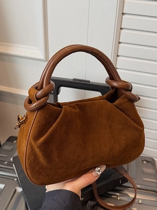 Brown suede ruched dumpling bag with leather knot handle and adjustable crossbody strap