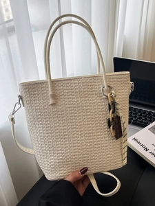 Off-white woven bucket bag with chocolate charm and chain detail shown in high capacity