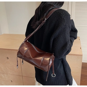 Nahaufnahme der zylindrischen Tasche aus braunem Glanzleder im Vintage-Stil