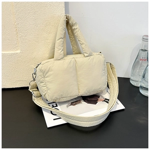 Detail of beige quilted puffer tote bag with wide shoulder strap and soft textured padding