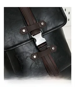Detail shot of the silver metal buckle and litchi texture on the black backpack
