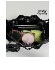 Vue de dessus montrant la grande capacité interne du sac seau noir en cuir à chaîne