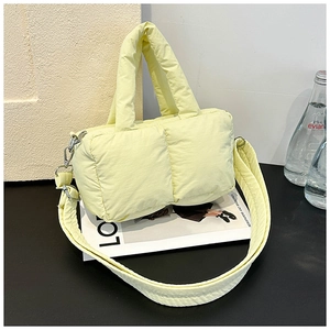 Detail of soft puffy light yellow quilted tote bag with padded handles and large capacity