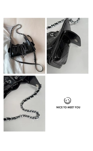 Détail du cuir matelassé noir et de la bandoulière en chaîne de ce sac fourre-tout