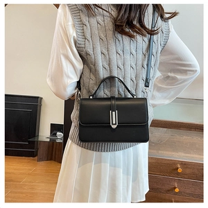 Chic black crossbody bag shown on a model wearing a grey sweater for lifestyle look