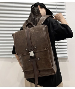 Side view of dark brown vintage leather backpack worn by a model in natural light