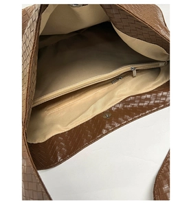 Detailed interior of woven brown tote bag showing central zipper pocket and magnetic closure