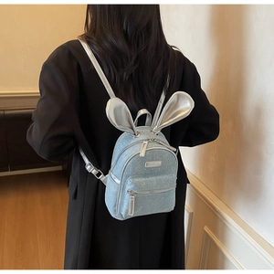 Light blue denim mini backpack featuring silver rabbit ears and polka dot texture on back