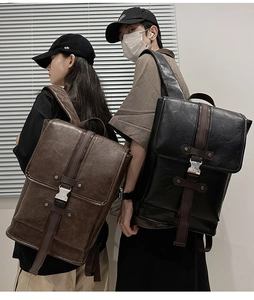 Detail of vintage PU leather backpacks with metal buckles in brown and black colors