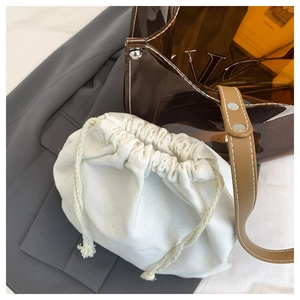Detailansicht der transparenten PVC-Tasche mit weißem Canvas-Innenbeutel und Lederriemen