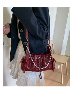 Vue détaillée du sac bandoulière matelassé bordeaux avec chaîne argentée et cordon