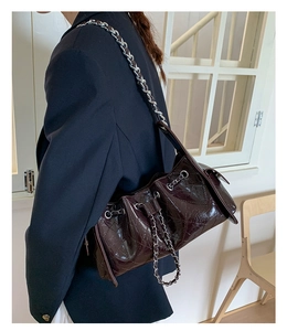 Détail du sac matelassé en cuir verni bordeaux avec bandoulière chaîne sur modèle