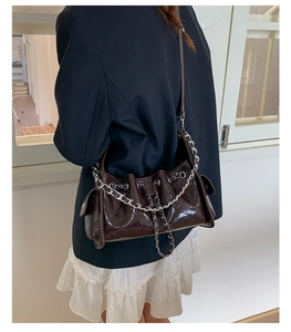 Détails du sac bandoulière en cuir verni marron foncé avec matelassage et chaîne argent