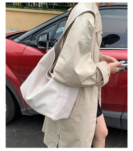 Lifestyle shot of large woven tote bag in cream finish with detailed lattice pattern