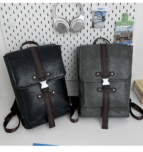 Close-up of black and grey textured PU leather backpacks with silver buckles