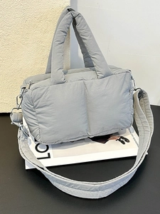 Chic grey quilted puffer tote bag with soft padded handles and a wide shoulder strap