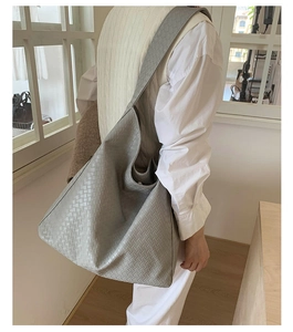 Detail view of grey woven leather hobo bag showing large capacity and soft texture