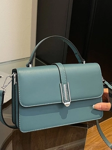 Fashionable teal leather square handbag with top handle and silver metal clasp detail