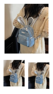 Detail of blue denim mini backpack with silver rabbit ears and glitter finish
