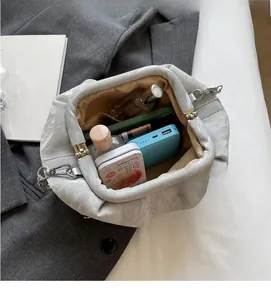 Interior view of pleated cloud bag showing capacity for power bank and cosmetics